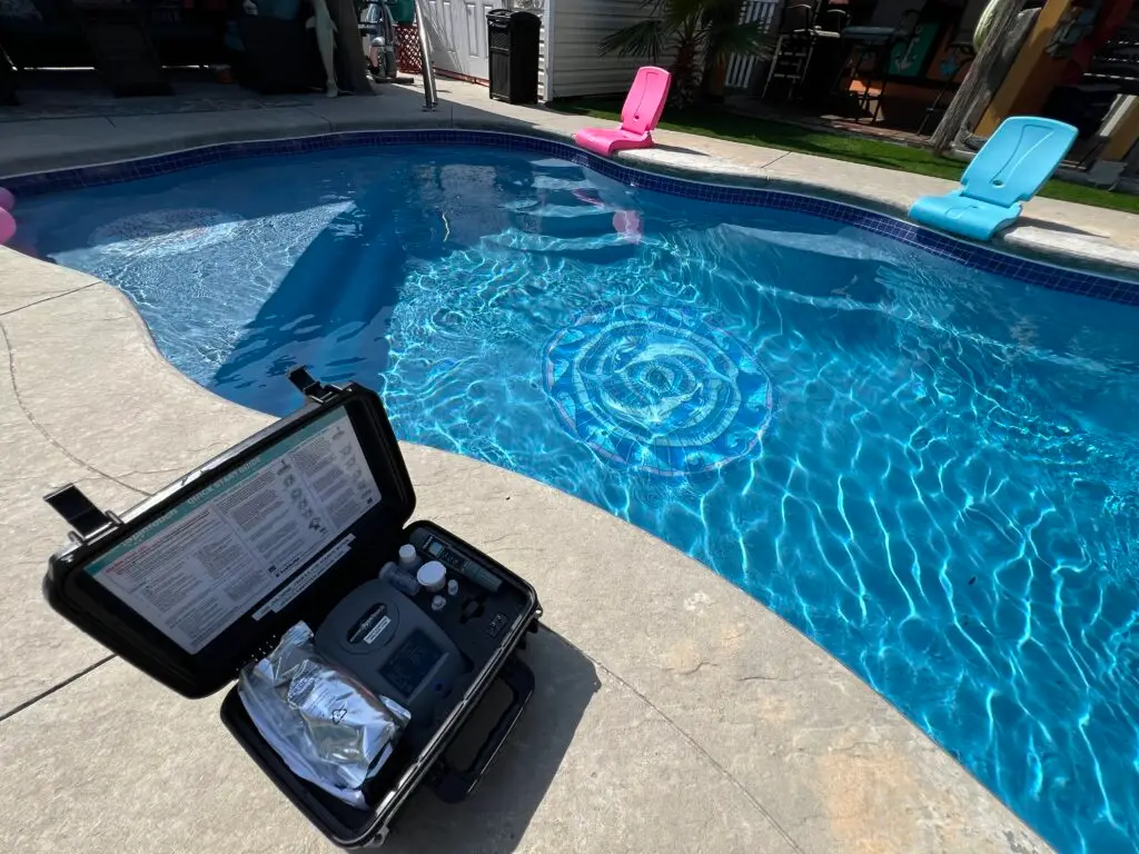 Trichlor tablets: the benefits and drawbacks Grey Shark Pool Services, Oak Island, NC: poolside on a sunny day, test kit on concrete edge, three pool chairs float in clear water.