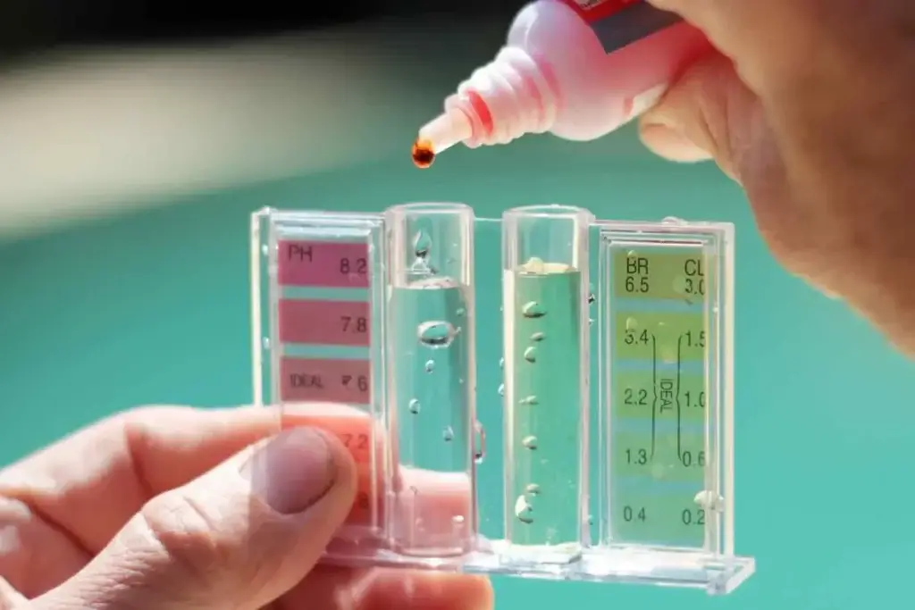 A person with Grey Shark Pool Services in Oak Island, NC tests pool water pH and chlorine levels using a kit, blue background blurred.